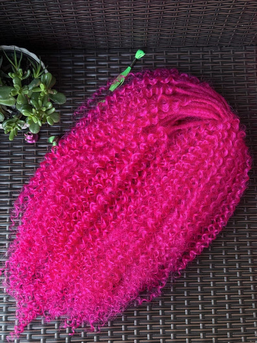 Bright pink curly DE hair extensions bundle showing tight curl texture