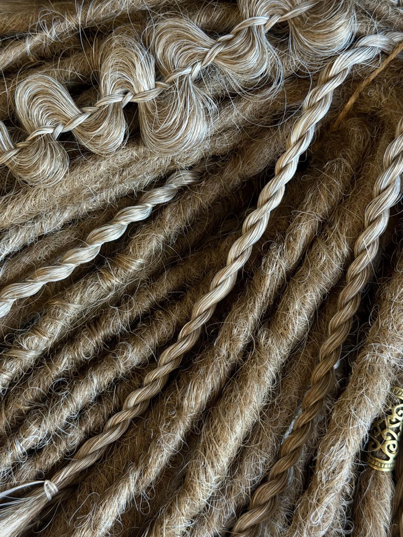 Close up of dense blonde textured dreadlocks showing handmade structure and smooth ombre blend