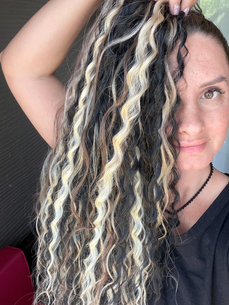 Woman wearing black and blonde wavy dreadlocks realistic boho hairstyle