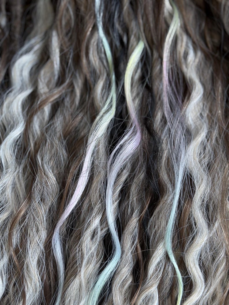 Detailed texture of handmade wavy synthetic dreads with smoky blonde and pastel rainbow accents