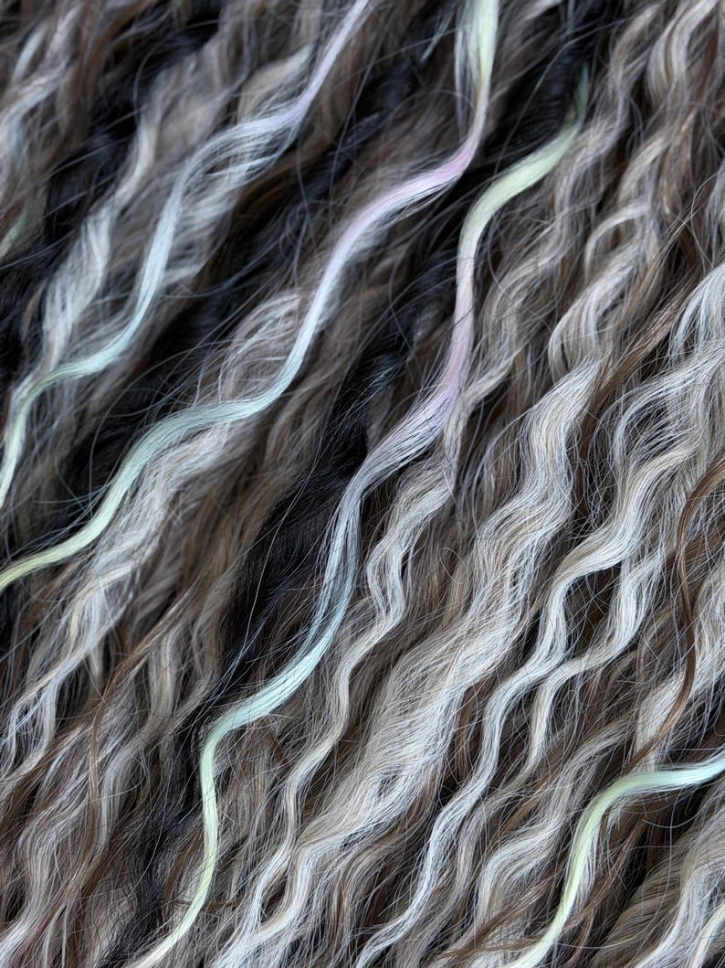 Close up of soft wavy dreadlock texture with pastel blue pink and mint accent strands