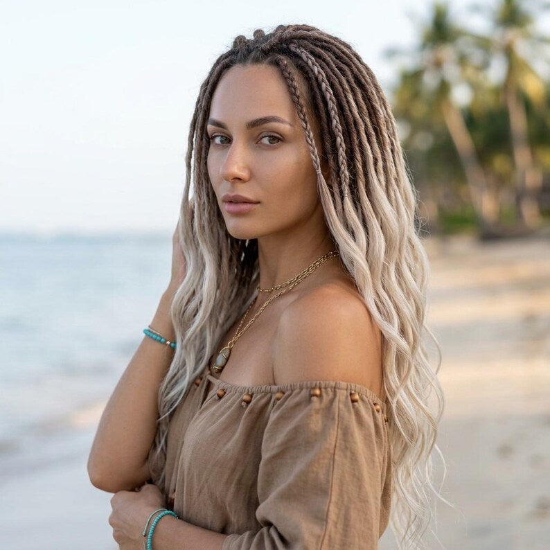 Luxury blonde dreadlock extensions on model with natural brown roots and beach hairstyle