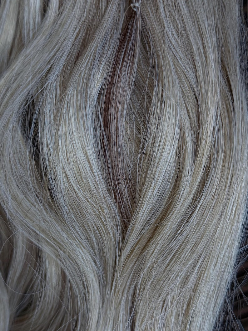 Close up of premium natural blonde synthetic hair showing soft realistic wavy texture
